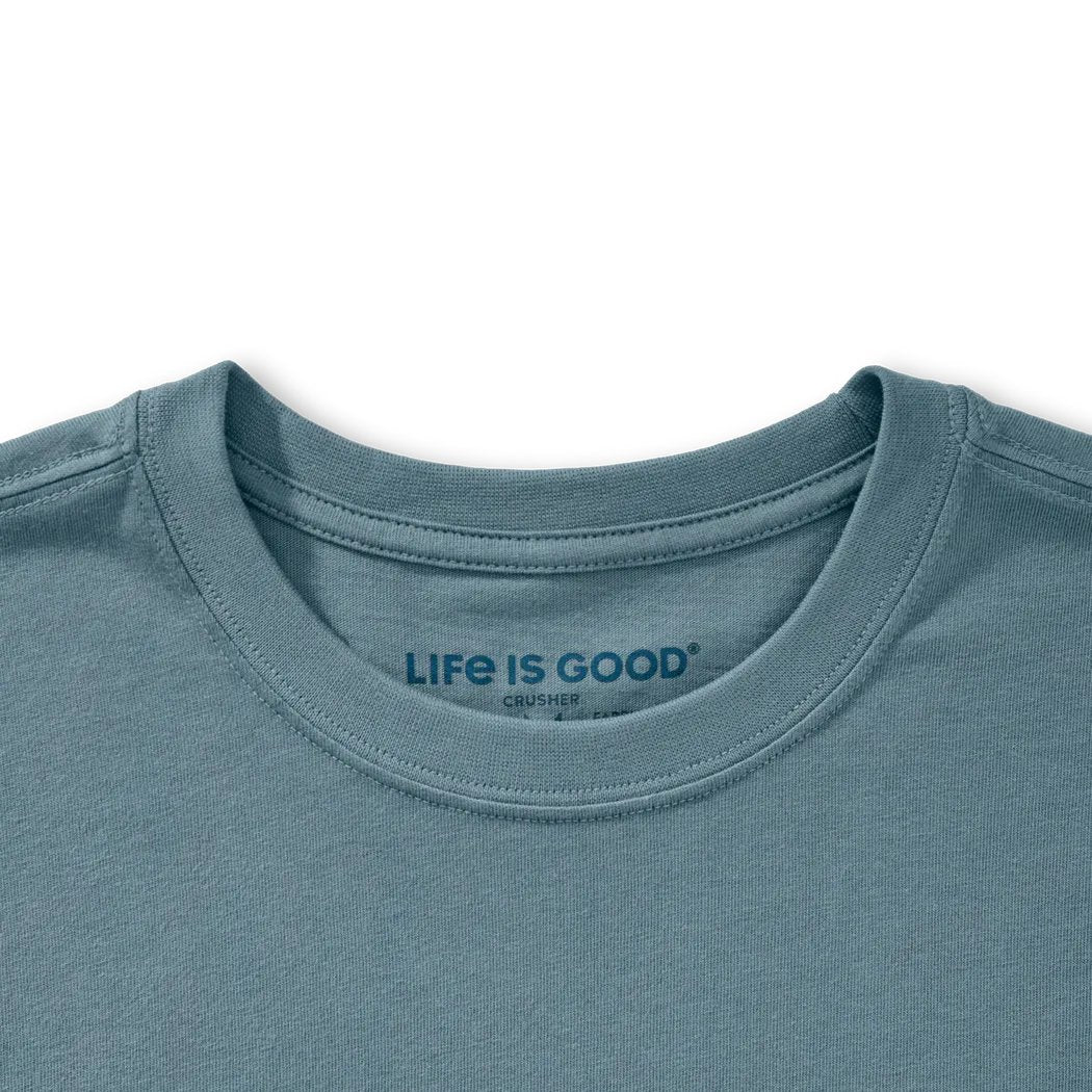 A close-up of the Life is Good Men's Free Hugs Shark Short Sleeve Crusher-LITE Tee in Slate Blue showing the collar and tag against a white background.