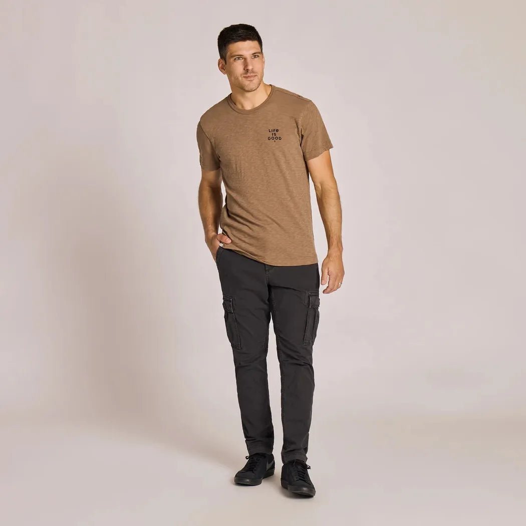 A front view of the Life is Good Men's Mountain Landscape Short Sleeve Slub Slim Fit Tee in Mushroom Brown on a model against a light background.