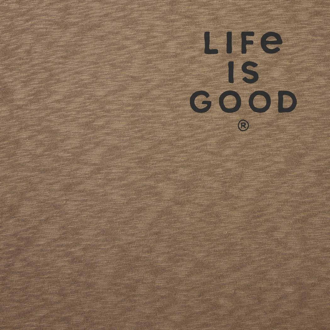 A close-up of the Life is Good Men's Mountain Landscape Short Sleeve Slub Slim Fit Tee in Mushroom Brown showing the "Life is Good" logo on the chest.
