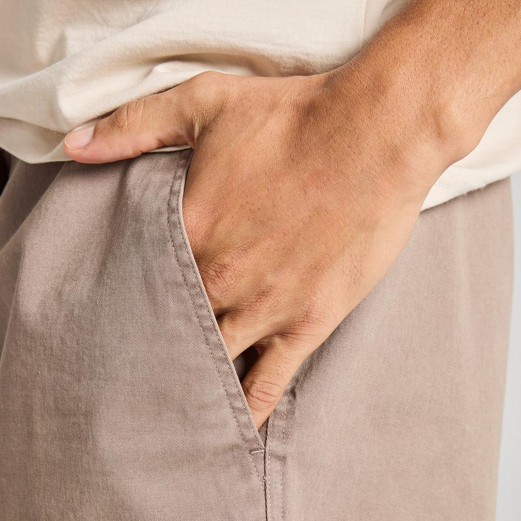 A hand in the pocket of the Life is Good Men's Solid Weekender Short in Mushroom Brown, showing the side seam and pocket detail.