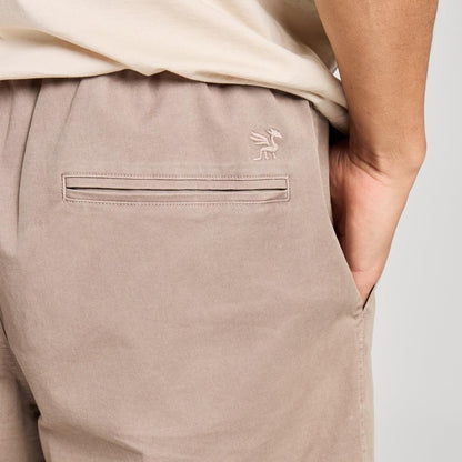 Back view of the Life is Good Men's Solid Weekender Short in Mushroom Brown showing the back pocket and model's hand in pocket.