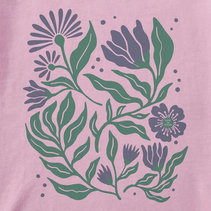 A violet purple Life is Good Women's Array of Flowers Short Sleeve Crusher Tee with green leaves and flowers on a pink background.