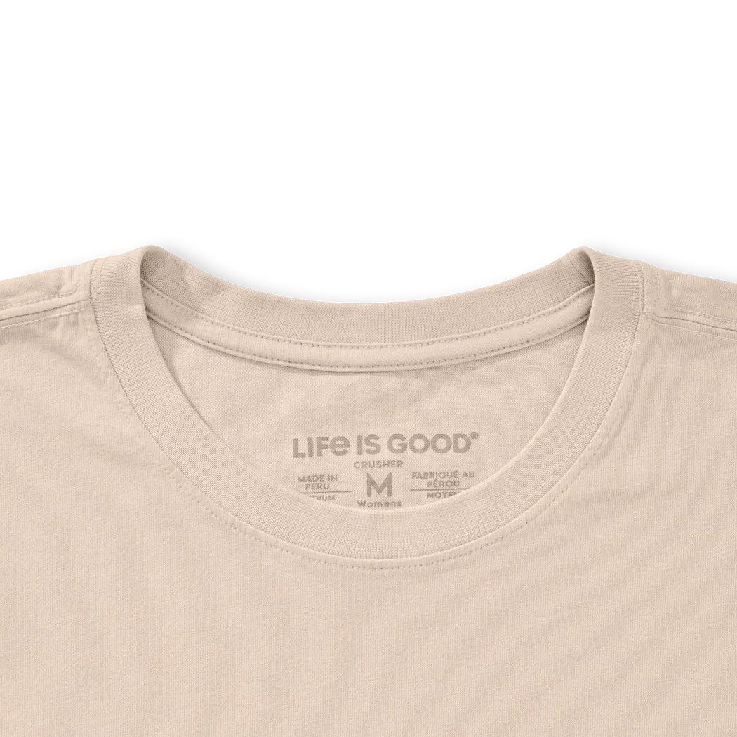 A close-up of the Life is Good Women's Collection of Mushrooms Short Sleeve Crusher Tee in Birch White showing the neck label against a white background.