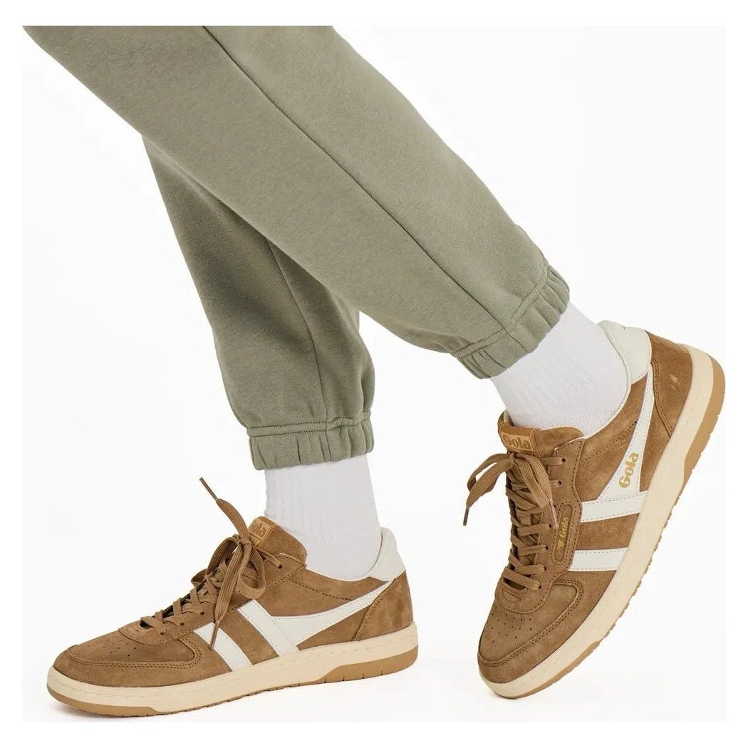 A model wearing Moss Green Life is Good Women's Solid Vibes Fleece Joggers and brown sneakers with white stripes.