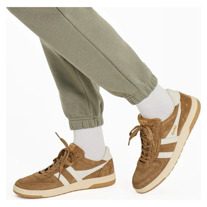 A model wearing Moss Green Life is Good Women's Solid Vibes Fleece Joggers and brown sneakers with white stripes.