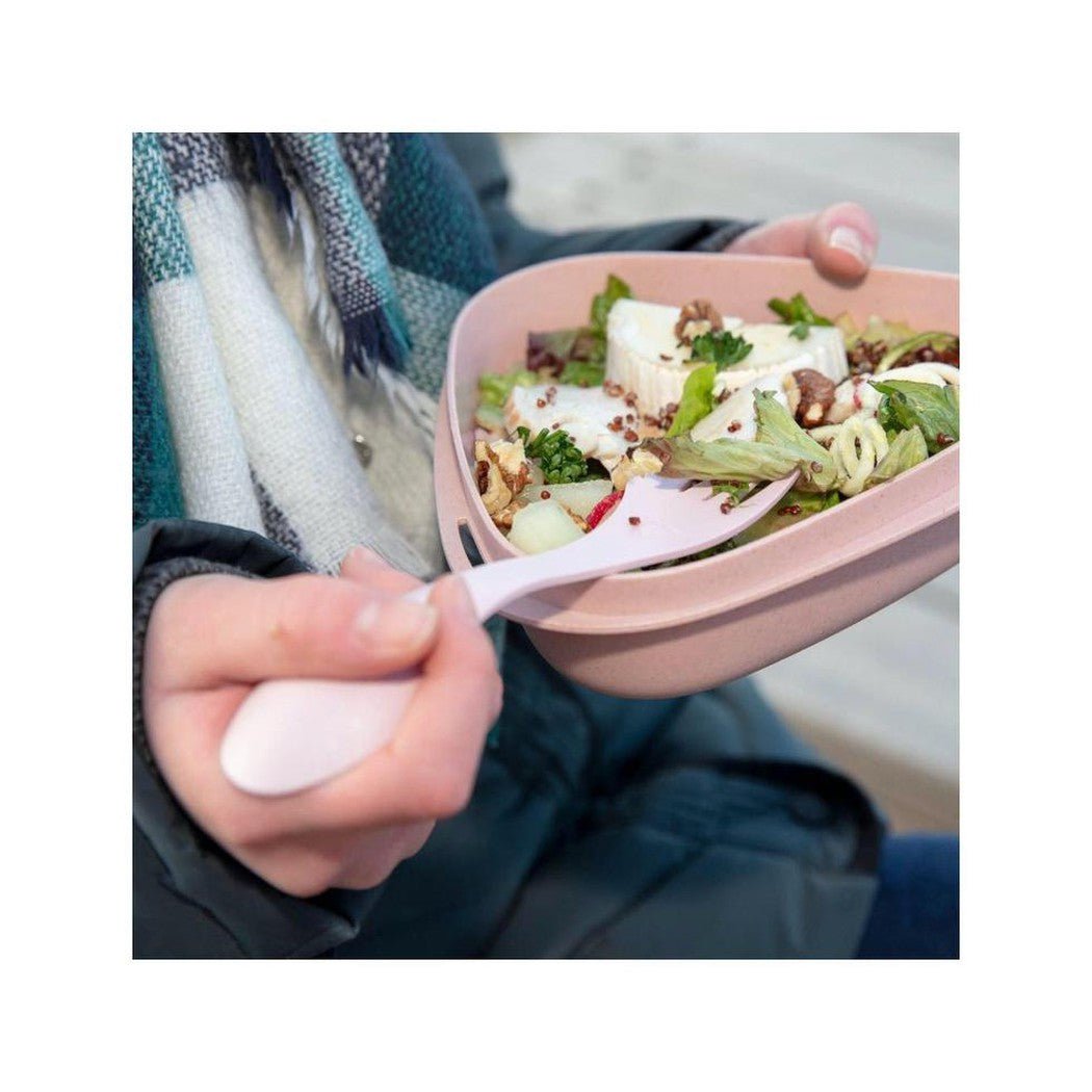 A person in a Deeply Blue jacket holds a Light My Fire Spork Original BIO with a pink bowl of salad in the background.