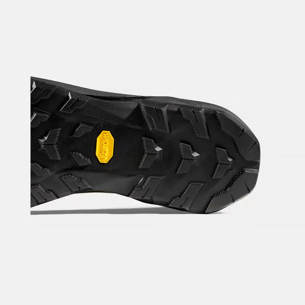 The sole of the Mammut Ducan III High LTH GTX Men boot in Moor Black is shown from a low angle with a yellow brand tag and rugged tread pattern against a white background.