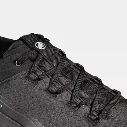 A close-up of the Mammut Sertig III Low GTX Men in Gabbro Strata, showing the lacing system and textured upper against a light background.