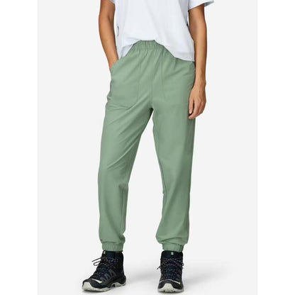 Side view of the Marmot Women's AirExchange SolarShield Jogger in Agate Green on a model wearing black sneakers against a white background.