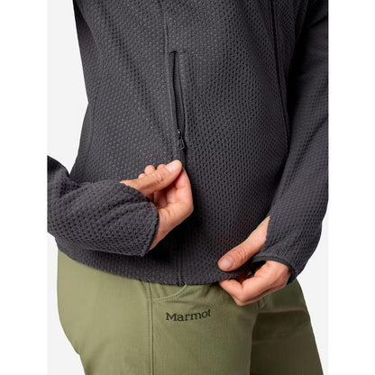 A close-up of the Marmot Women's AirFleece Jacket in Blackened, showing a model's hand near the zipper and olive green Marmot pants against a plain background.