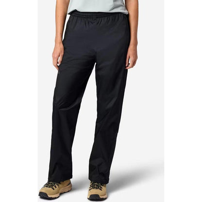 A front view of the Marmot Women's PreCip Evo Pant in Black, showing the elastic waistband and a model wearing tan hiking shoes against a plain white background.