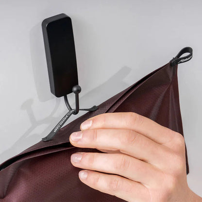 A hand holds the Arctic White Matador FlatPak Zipper Toiletry Case against a light gray background.