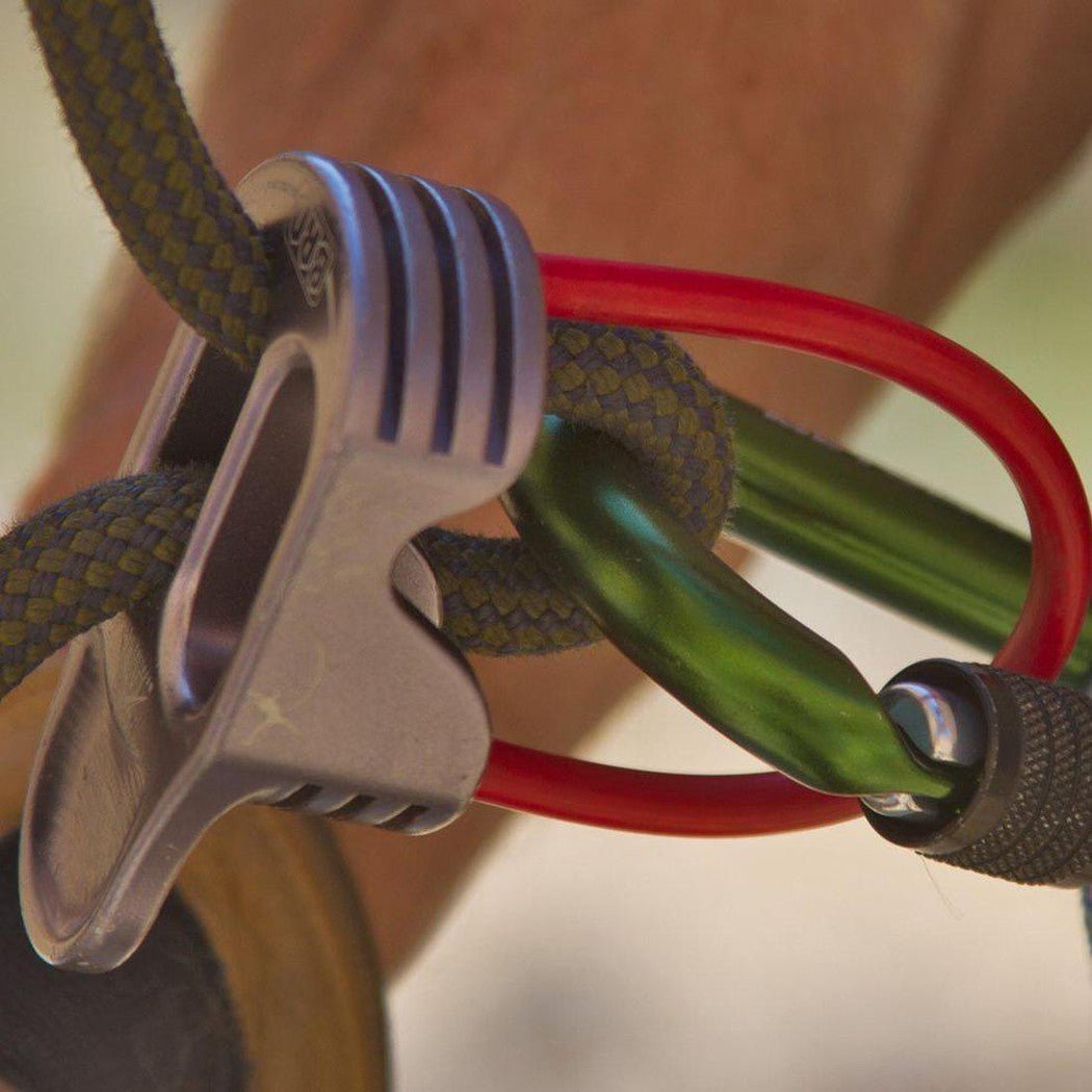 A close-up of the Metolius Element Locker carabiner in Black, showing its locking mechanism and attached to a red and green climbing rope.