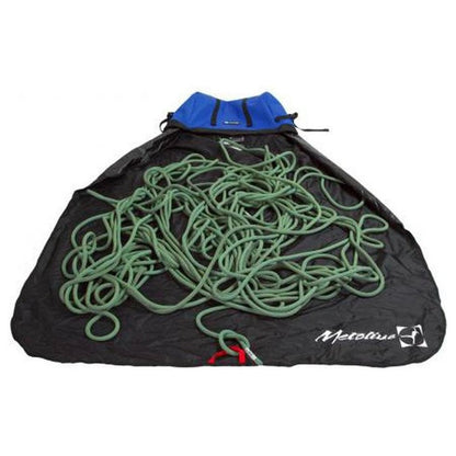 A blue Metolius Ropemaster HC rope bag holds a green climbing rope on a black surface.