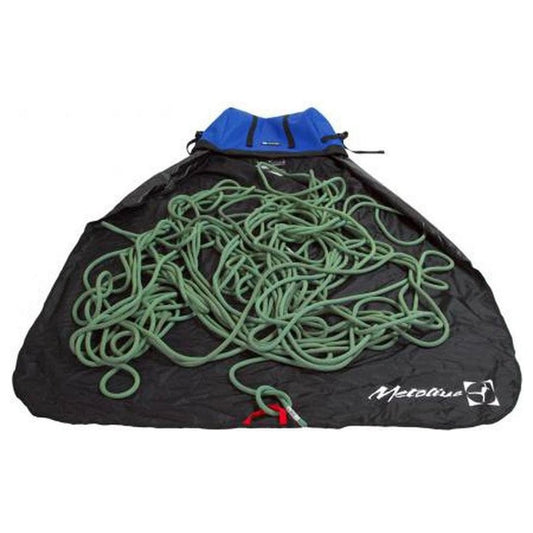 A blue Metolius Ropemaster HC rope bag holds a green climbing rope on a black surface.