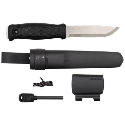 A top-down view of the Morakniv Garberg Survival knife with its black sheath, fire starter, and lanyard against a white background.