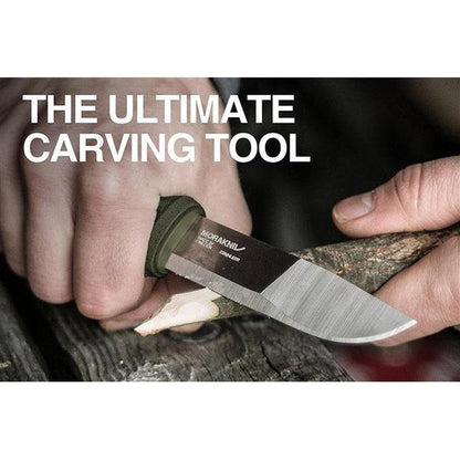 A hand holds the Morakniv Kansbol Knife with a green handle while carving wood.