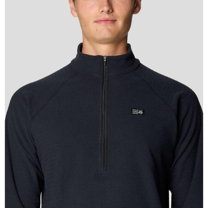 A front view of the Mountain Hardwear Men's Summit Grid Half Zip in Black, showing the half zip and logo on a model against a light gray background.