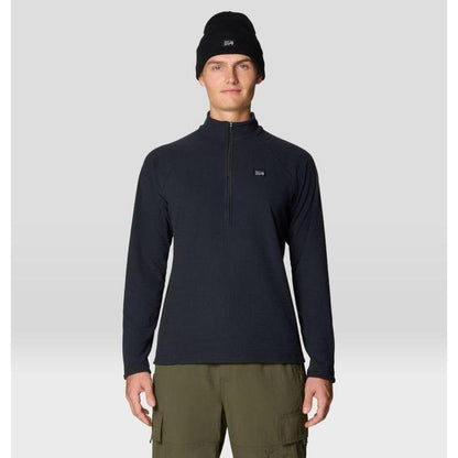 A front view of the Mountain Hardwear Men's Summit Grid Half Zip in Black on a model wearing cargo pants against a light gray background.