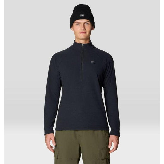 A front view of the Mountain Hardwear Men's Summit Grid Half Zip in Black on a model wearing cargo pants against a light gray background.
