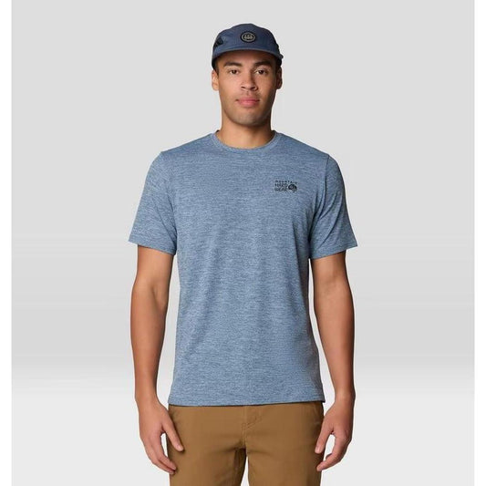 A front view of the Mountain Hardwear Men's Sunblocker Short Sleeve in Adriatic Blue Heather on a model wearing khaki pants against a light gray background.