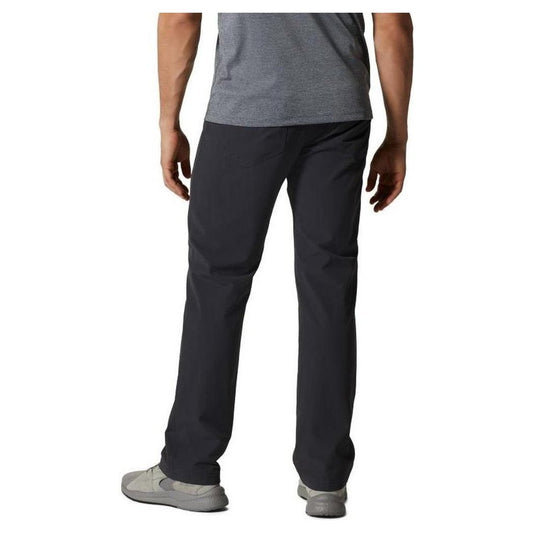 Back view of the Mountain Hardwear Men's Yumalino Lined Pant in Dark Storm on a model wearing gray sneakers against a white background.