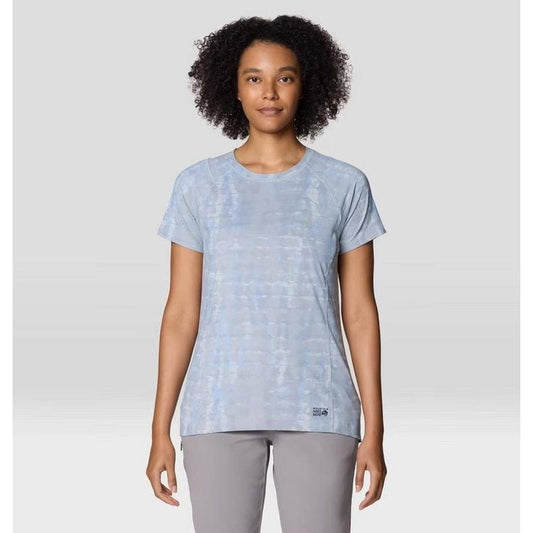 A front view of the Mountain Hardwear Women's Crater Lake Short Sleeve in Glacial Prismatic Print on a model wearing gray pants against a light background.