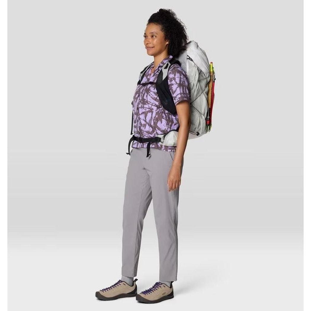 Side view of the Mountain Hardwear Women's Dynama Ankle Pant in Black, showing the model wearing them against a plain background.