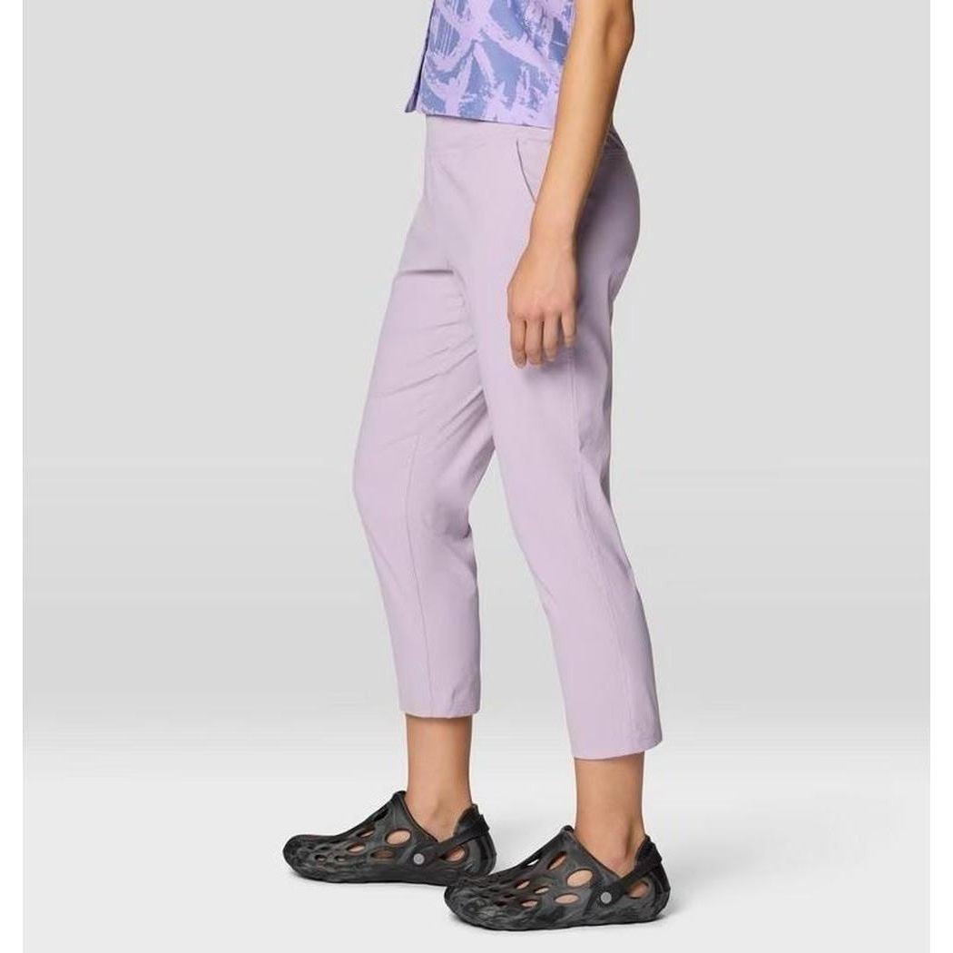 Side view of the Mountain Hardwear Women's Dynama Crop in Atmospheric showing the cropped length and black shoes against a light background.