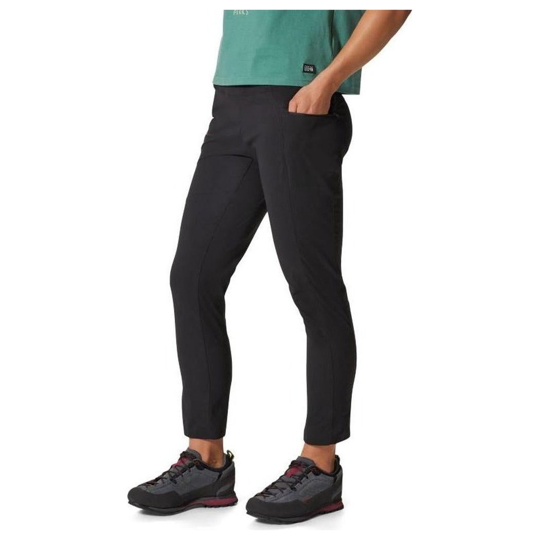 Side view of the Mountain Hardwear Women's Dynamam High Rise Ankle Pant in Black, showing the model wearing it against a white background.