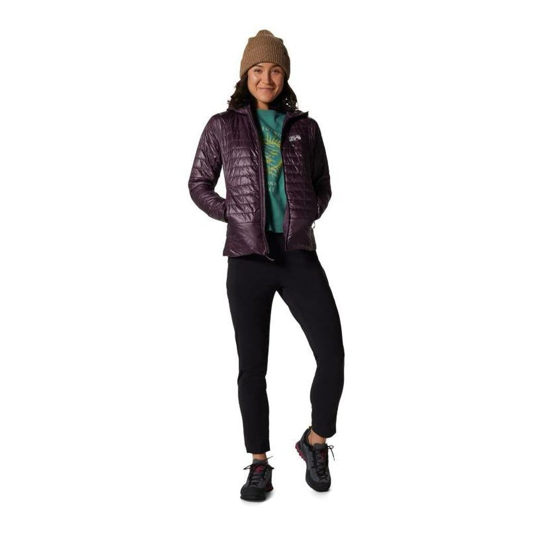 A woman wearing the Mountain Hardwear Women's Dynamam High Rise Ankle Pant in Black stands against a white background.