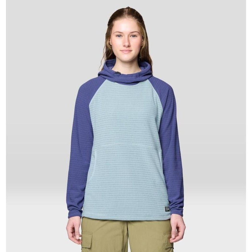 A front view of the Mountain Hardwear Women's Summit Grid Tunic Hoody in Ice Shadow/Lapis Dusk on a model wearing khaki cargo pants against a light gray background.