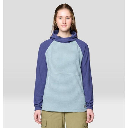 A front view of the Mountain Hardwear Women's Summit Grid Tunic Hoody in Ice Shadow/Lapis Dusk on a model wearing khaki cargo pants against a light gray background.