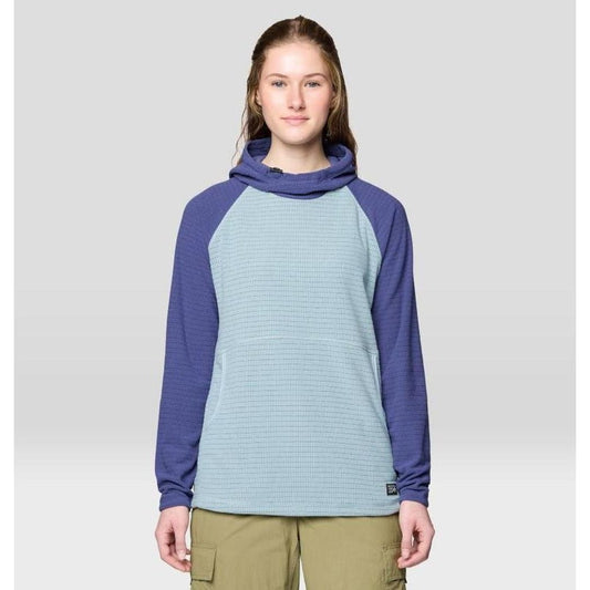 A front view of the Mountain Hardwear Women's Summit Grid Tunic Hoody in Ice Shadow/Lapis Dusk on a model wearing khaki cargo pants against a light gray background.