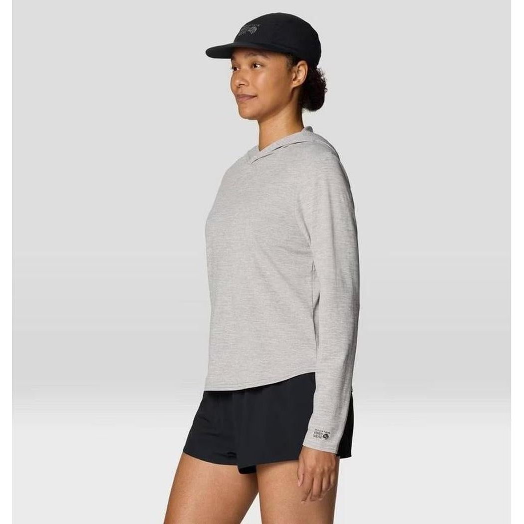 Side view of the Mountain Hardwear Women's Sunblocker Long Sleeve Hoody in Half Moon Grey on a model wearing black shorts against a light background.