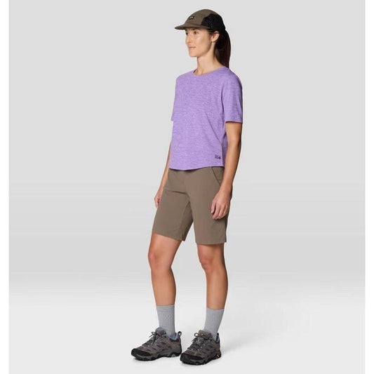 Side view of the Mountain Hardwear Women's Sunblocker Short Sleeve in Harbor Violet on a model wearing gray socks and shoes against a plain background.