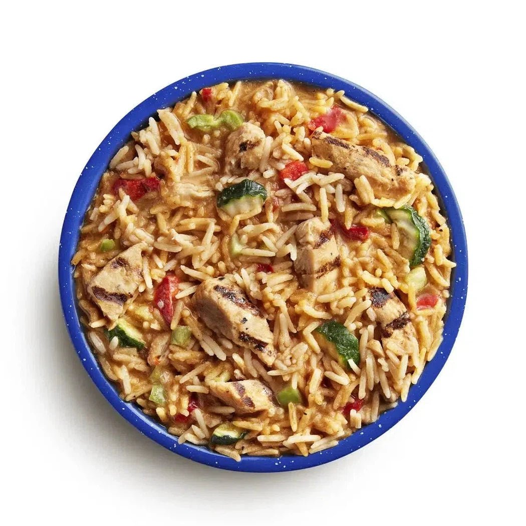 A top-down view of the Mountain House Kung Pao Chicken (GF) in a blue bowl with visible chicken, rice, and vegetables.