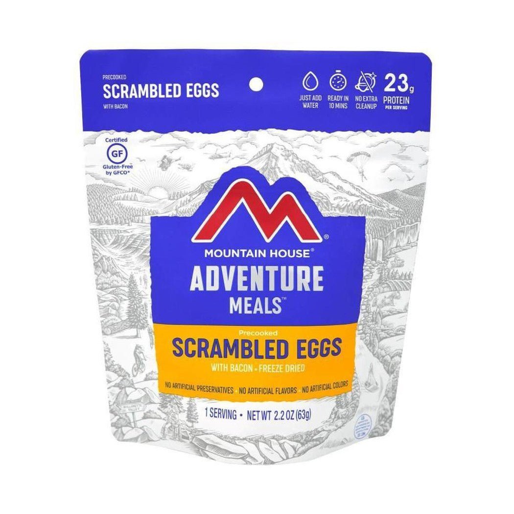 A front view of the Mountain House Scrambled Eggs with Bacon backpacking meal package showing the blue and yellow label against a white background.