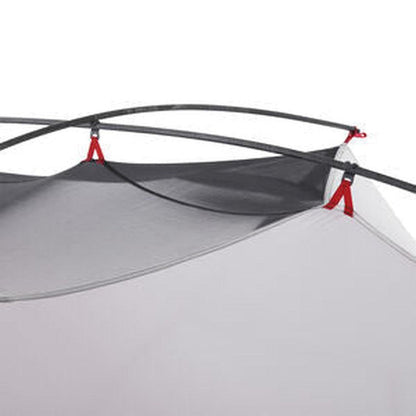 The MSR Hubba Hubba 2 Tent V9 shows the mesh and gray fabric with red tie-downs and black poles against a white background.