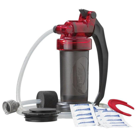 A front view of the MSR MiniWorks EX Purifier System with its red and black handle, charcoal filter, and cleaning packets on a white background.