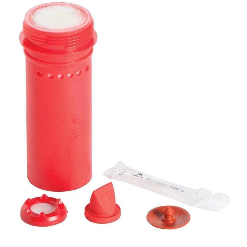 A red MSR TrailShot Replacement Cartridge with its cap, filter, and instructions laid out on a white background.