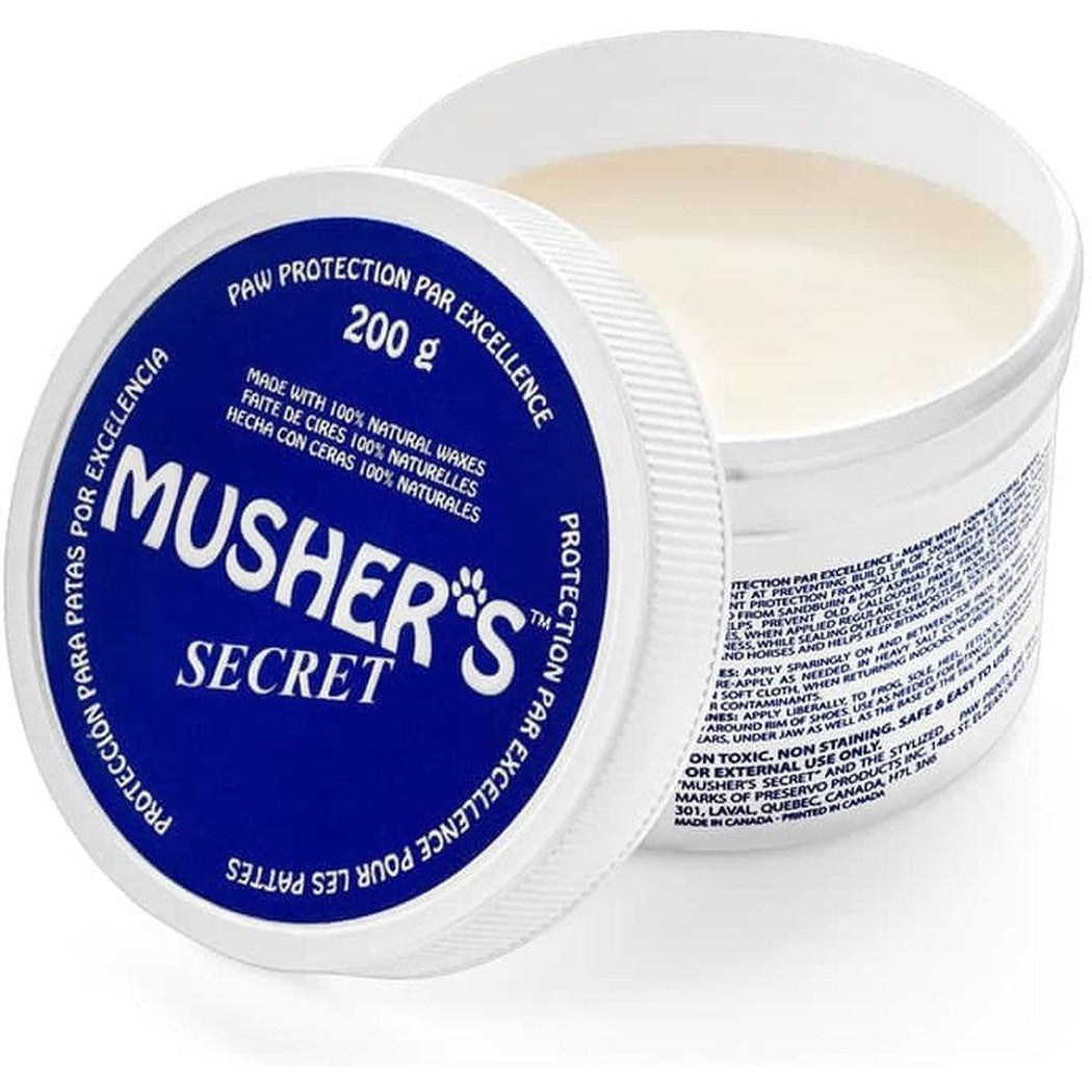 A close-up of a blue and white Musher's Secret paw protection container showing the lid and the product inside.