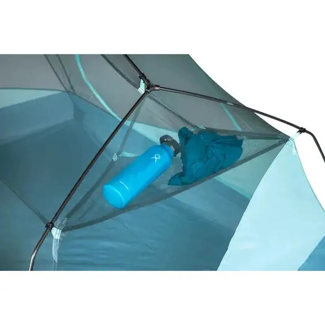 A close-up of the NEMO Aurora 3P & Footprint tent in Frost/Silt color, showing the interior mesh pocket with a blue water bottle and a blue item inside.