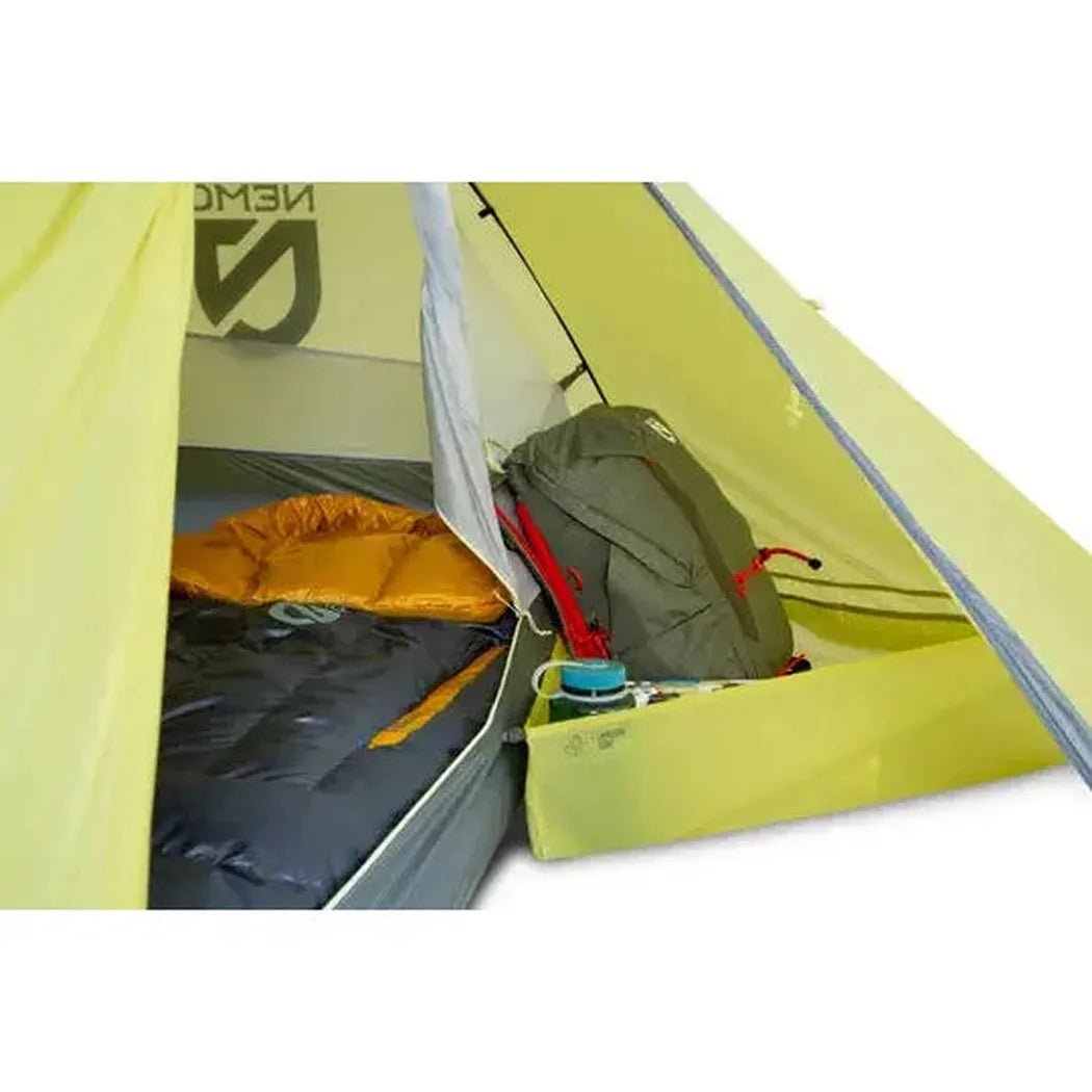 Inside the NEMO Dagger OSMO Lightweight Backpacking 2p Tent, a charcoal sleeping bag and olive backpack sit on the floor.