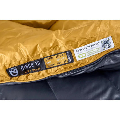 A close up of the NEMO Disco 15 Men's sleeping bag showing the yellow and black color and the Endless Promise label.