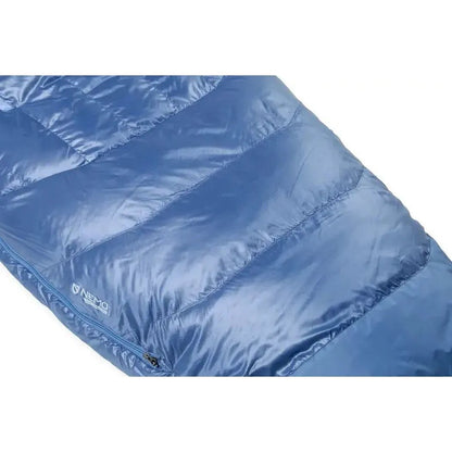 A blue NEMO Disco Women's Endless Promise 30 Down sleeping bag with a zipper and logo visible, shown from a side angle.