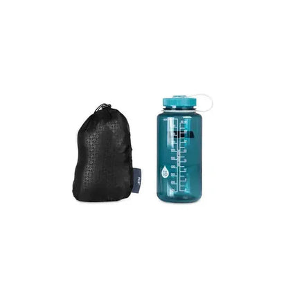 A black NEMO Fillo Backpacking & Camping Pillow next to a teal water bottle on a white background.
