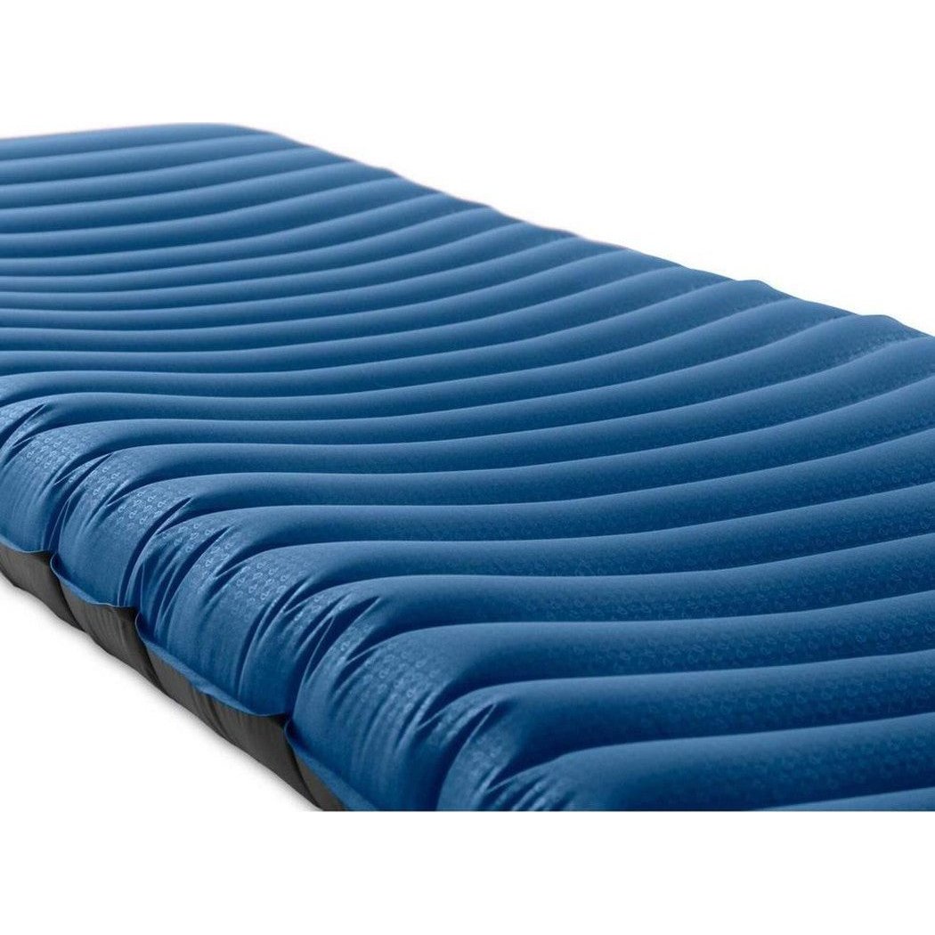 A close-up side view of the NEMO Quasar 3D Insulated sleeping pad with its blue 3D wave pattern against a white background.