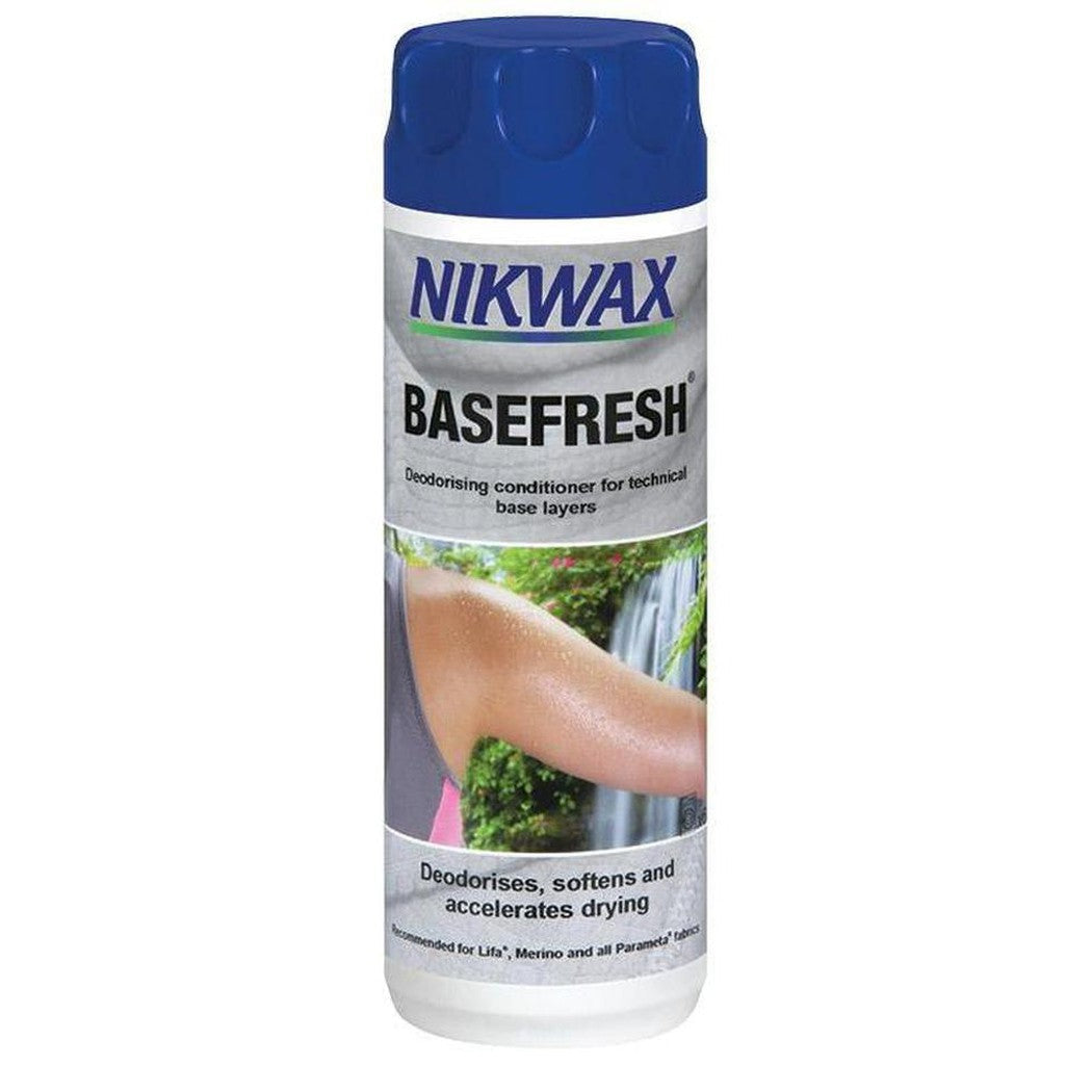 A front view of the Nikwax Basefresh deodorizing conditioner bottle with a blue cap and a nature scene background.