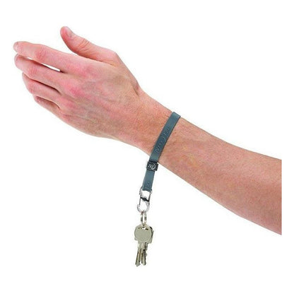A hand wears the Nite Ize Cinch-A-Lot Stretch Strap in Blue, showing the key attachment and silver hardware against a white background.